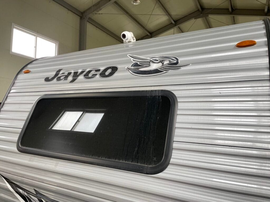 제이코(Jayco) 브랜드 로고가 새겨진 카라반 전면부 상단 지붕 라인 중앙에 4채널 시스템 완성을 위해 장착된 전방 CCTV 카메라