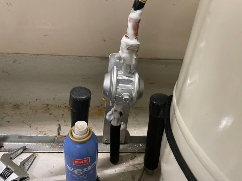 호스 교체 후 가스 누출 탐지액을 분사하여 기밀을 확인하는 카라반 LPG 가스 안전 점검